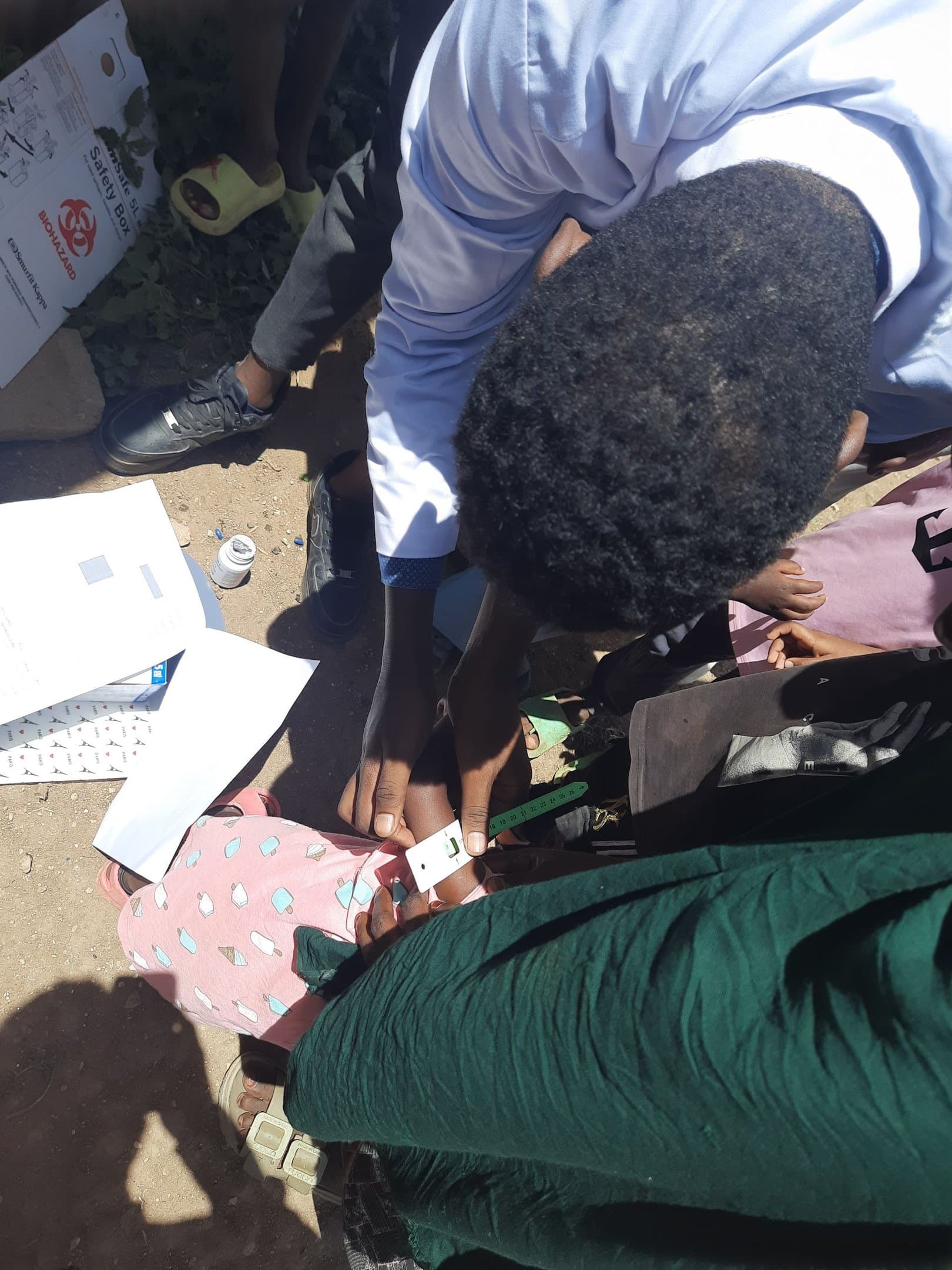 A SHIFA health worker measuring a child's arm circumference to screen for malnutrition